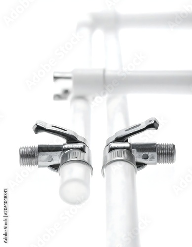 Metal Pipe Clamps Aligned on White Tubes in Minimal Studio Background
