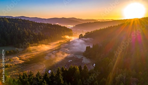 Golden Sunrise Illuminating Misty Forest Valley in Mountain Landscape