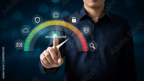 Businessman Pointing at Virtual Security Score Gauge with Cyber Protection Icons, Data Privacy Analysis, Cybersecurity Risk Assessment, Network Compliance and Tech Optimization