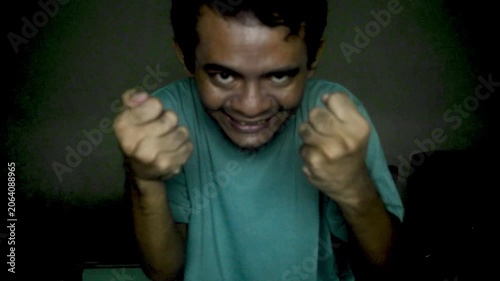 Sinister Man With Evil Expression Reaching Towards Camera In Dimly Lit Room