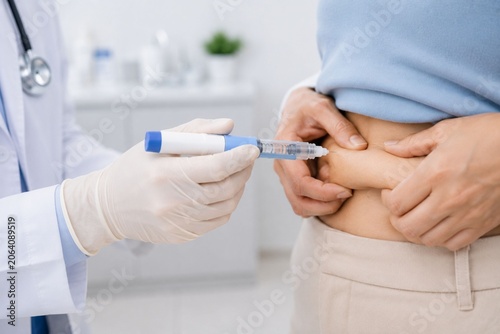 Close-up of doctor administering injectable weight management treatment to a patient in modern medical clinic