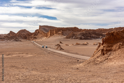 Vehicles crossing Valle de la Luna desert road in Atacama