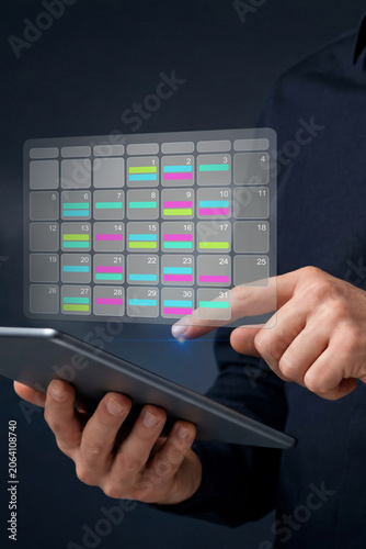 Calendar management for business scheduling. Digital calendar organization and appointment planning. Business professional using tablet calendar application.