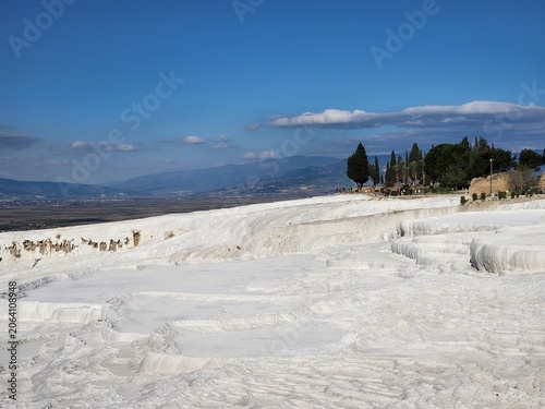 Fotografie White Travertine Pools of Pamukkale Under Blue Sky