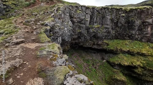 Close Aerial View of Múlagljúfur Canyon Cliff Face and Waterfall in Iceland from Low Drone Flight