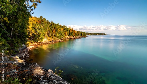 Colorful Autumn Forest Meeting Calm Turquoise Water Along Rocky Lakeshore