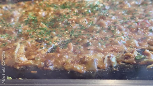 日本のもんじゃ焼き。鉄板焼き料理。キャベツや鶏肉で作るカレー味のもんじゃの動画。