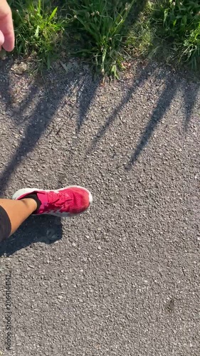 donna che cammina sulla strada con scarpe rosa