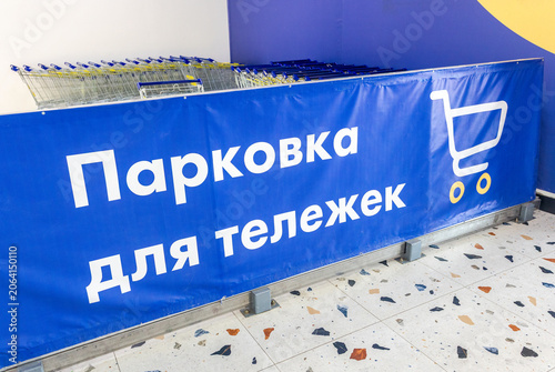 Parking lot for shopping carts at a store. Text in russian: Parking lot for shopping carts