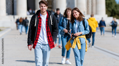 Group of young students walking outdoors on city campus