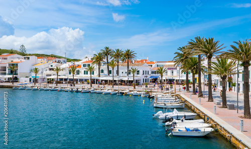 Obraz na plátně Panoramic view of whitewashed Fornells waterfront with boats and palm trees on n