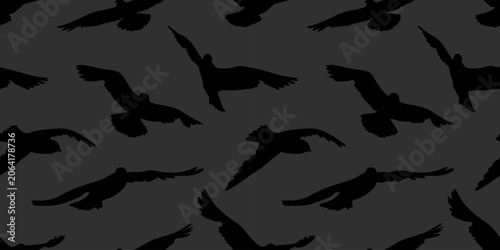 Dark abstract seamless pattern with black silhouettes of flying seagulls soaring over charcoal gray background. Moody minimal vector bird texture for contemporary wallpaper and fashion fabric prints