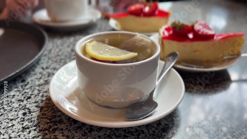 Hot Cup Of Tea With Lemon And Delicious Strawberry Cheesecake In Cafe Concept