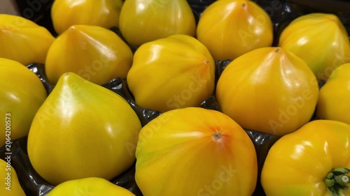 Yellow heirloom tomatoes in black packaging