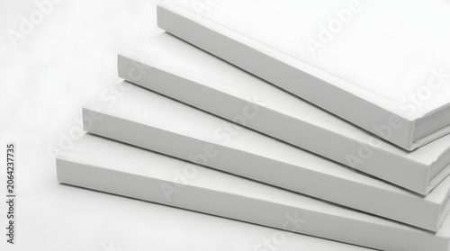Stack of four blank white hardcover books arranged in a minimalist diagonal pattern on white background