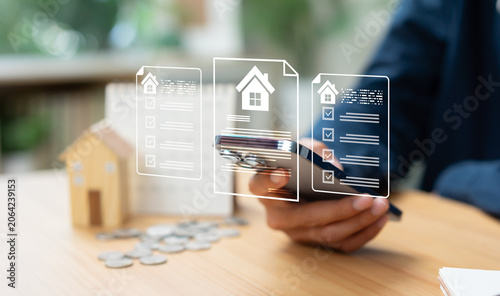 Slika na platnu Businessman reviewing property documents and housing market information on smart