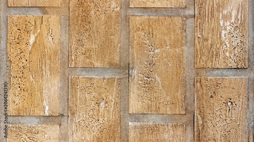 background of the natural cork travertine wall panels is a warm ochre—sandy beige, Lined with organic blocks with gray cement seams