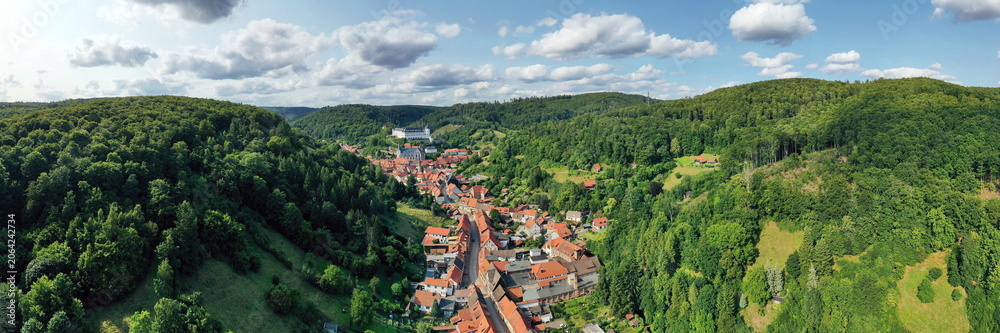 Fototapeta premium Malerische Luftaufnahme von Stolberg im Harz mit historischen Fachwerkhäusern, eingebettet in die grüne Berglandschaft mit Blick auf das Schloss. Perfekt für Tourismus und Reisen.