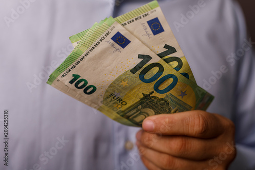 Man holding several one hun...