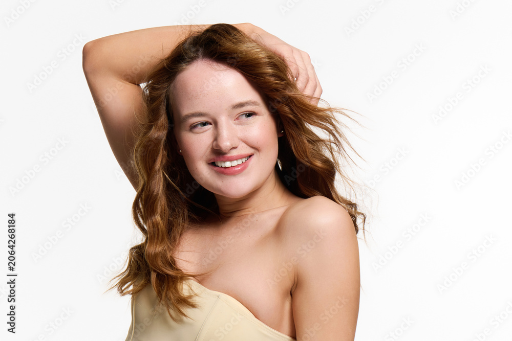 Fototapeta premium Young beautiful woman showcasing her captivating style in a vibrant studio setting