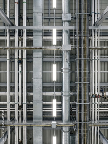 Factory ceiling infrastructure with ducts pipes rails for industrial facility