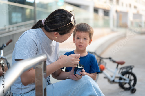 Mother and Son Enjoying Ice Cream Together Outdoors in Urban Setting
