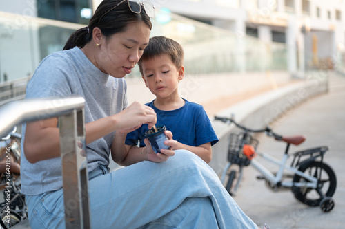 Mother and Son Enjoying Ice Cream Together Outdoors in Urban Setting