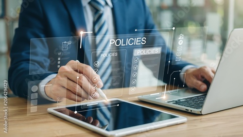 Business person reviewing company policies on a digital tablet at an office desk