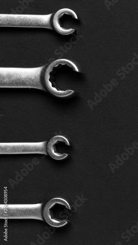 Wrenches arranged in vertical row on dark background, professional tool set for mechanical repair