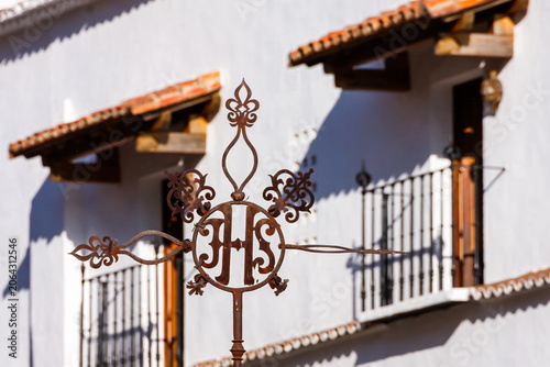 Wrought Iron Religious Symbol in Front of Andalusian Style Houses