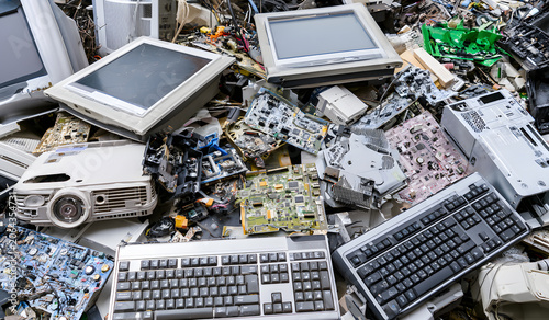 A heap of obsolete electronic gadgets such as computer monitors, circuit boards, projectors, and computer parts, symbolizing electronic waste (e-waste), is being considered for recycling