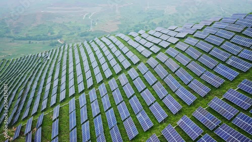 Aerial View of Solar Panels on Green Hillside Agrivoltaics Concept