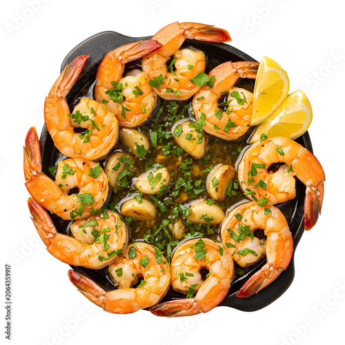 Gambas al ajillo spanish garlic shrimp with lemon and parsley in pan.