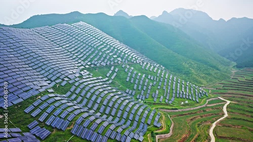 Aerial View of Solar Panels on Green Hillside Agrivoltaics Concept