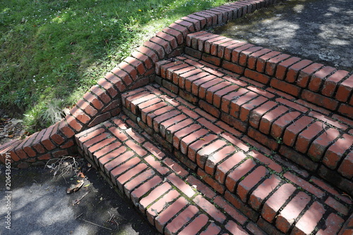 Bild auf Leinwand sun-dappled red brick steps beside landscaped lawn (close-up) 4230