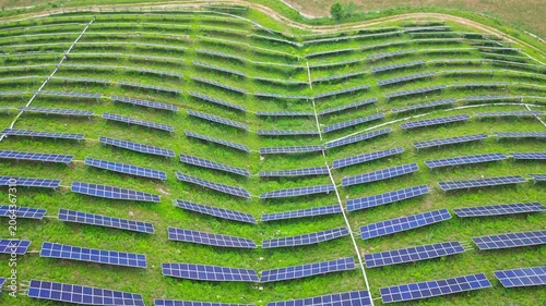 Aerial View of Solar Panels on Green Hillside Agrivoltaics Concept