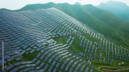 Aerial View of Solar Panels on Green Hillside Agrivoltaics Concept