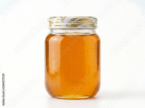 Glass jar filled with golden organic liquid honey