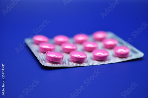 medication - pink pills on blue background 