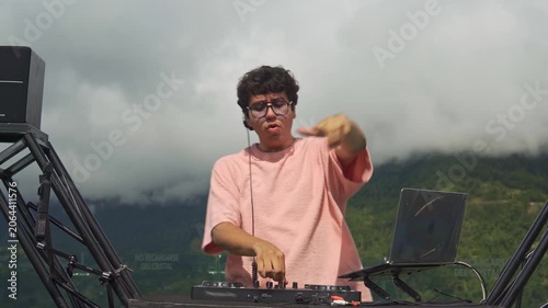Young dj mixing music at an outdoor festival in the mountains