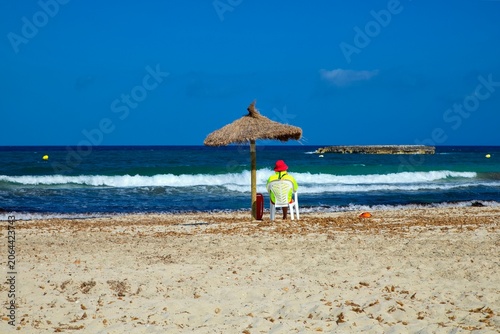 Lifeguard on the beach of Cala Moreia in the resort of S´illot on the island of Mallorca in the Balearic Islands in Spain.