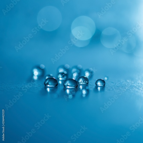 Close-Up of Water Droplets on a Surface with a Soft Blue Background and Bokeh Effect