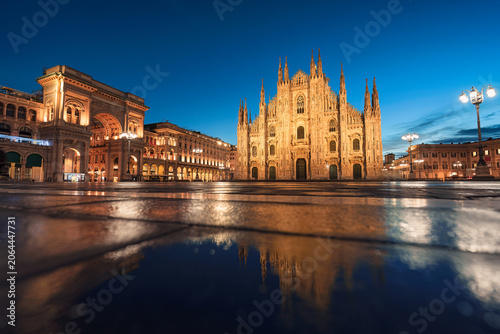 Illuminated Facade Duomo di Milano and Galleria Vittorio Emanuele II with water reflection in Piazza del Duomo, Milan