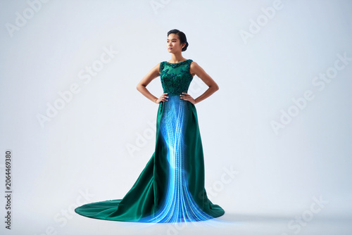 Woman in green gown with glowing blue light effect.