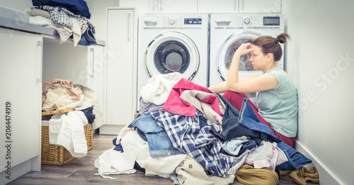 Fotografie Sad tired Woman in laundry room, blue tone