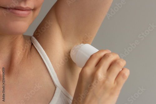 Foto Close up shot of a beautiful young woman using an antiperspirant or roll-on deodorant on on her armpit