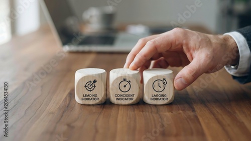 Hand holding business performance indicator blocks labeled leading coincident lagging