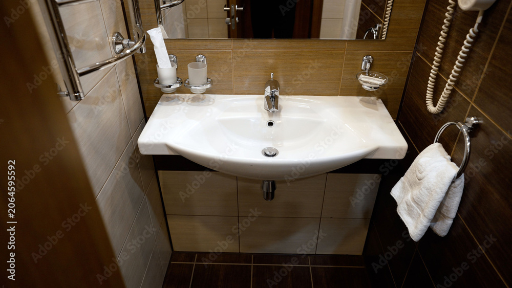 Fototapeta premium Modern bathroom interior with white ceramic sink and chrome fixtures