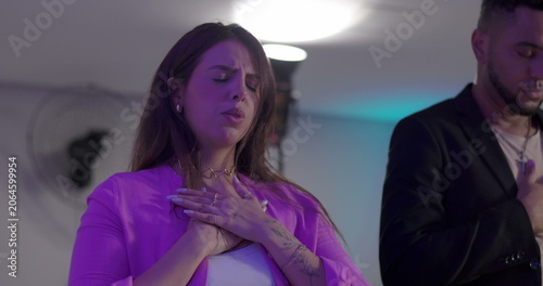 Fotografie Latin woman with hand on chest and eyes closed during evangelical worship, expre