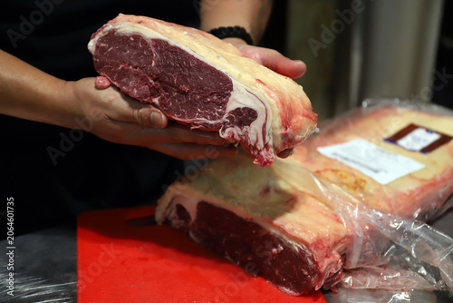 Canvastavla trozo grande de carne roja ternera cruda en manos del carnicero